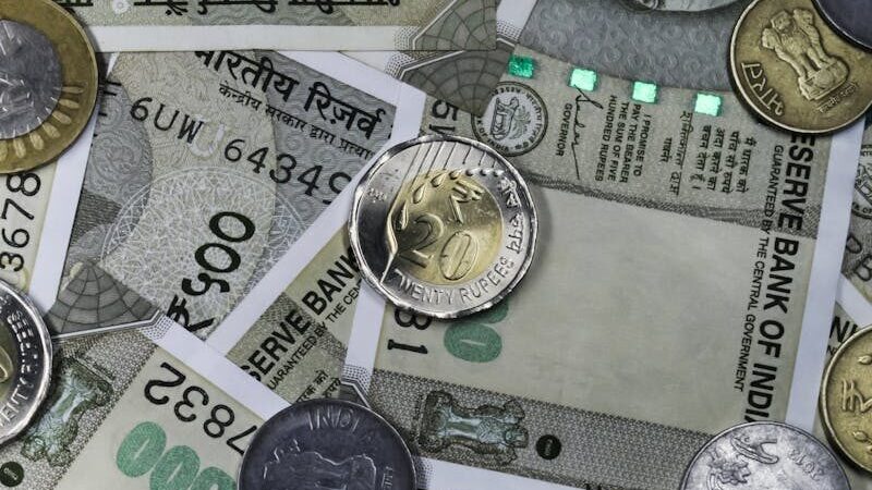 Top view of Indian rupees and coins depicting wealth and finance in India.