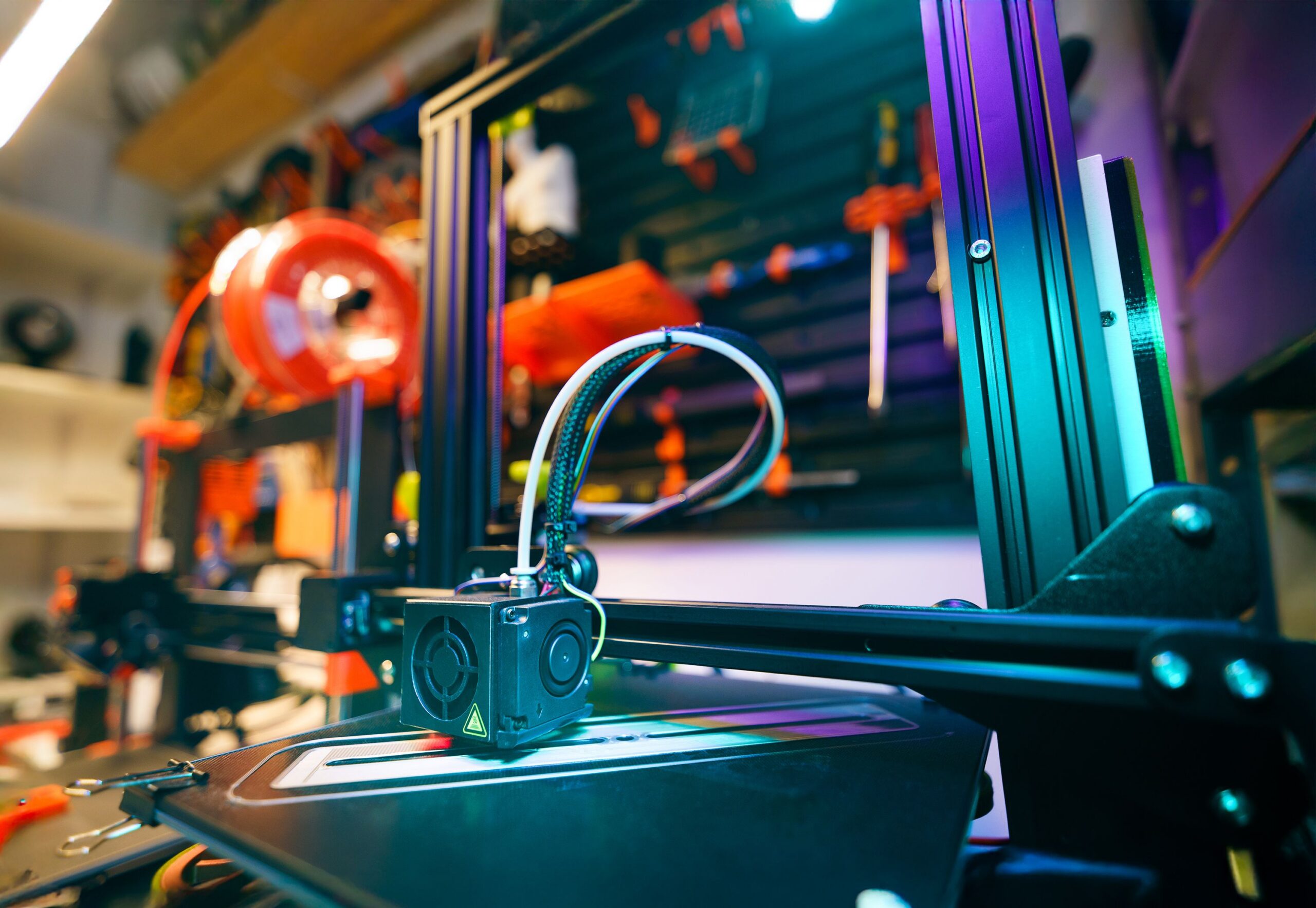 3D printer running in a ventilated home workshop with safety gear nearby